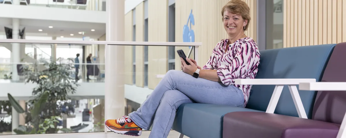 Patiënt na maagverkleining zittend op bank met Vitalys app